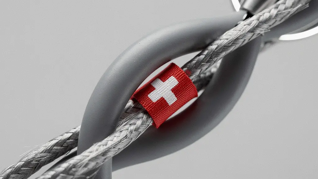 Gros plan macro d’un stéthoscope et d’un câble réseau entremêlés, symbolisant les métiers de la santé et de l’informatique en Suisse.